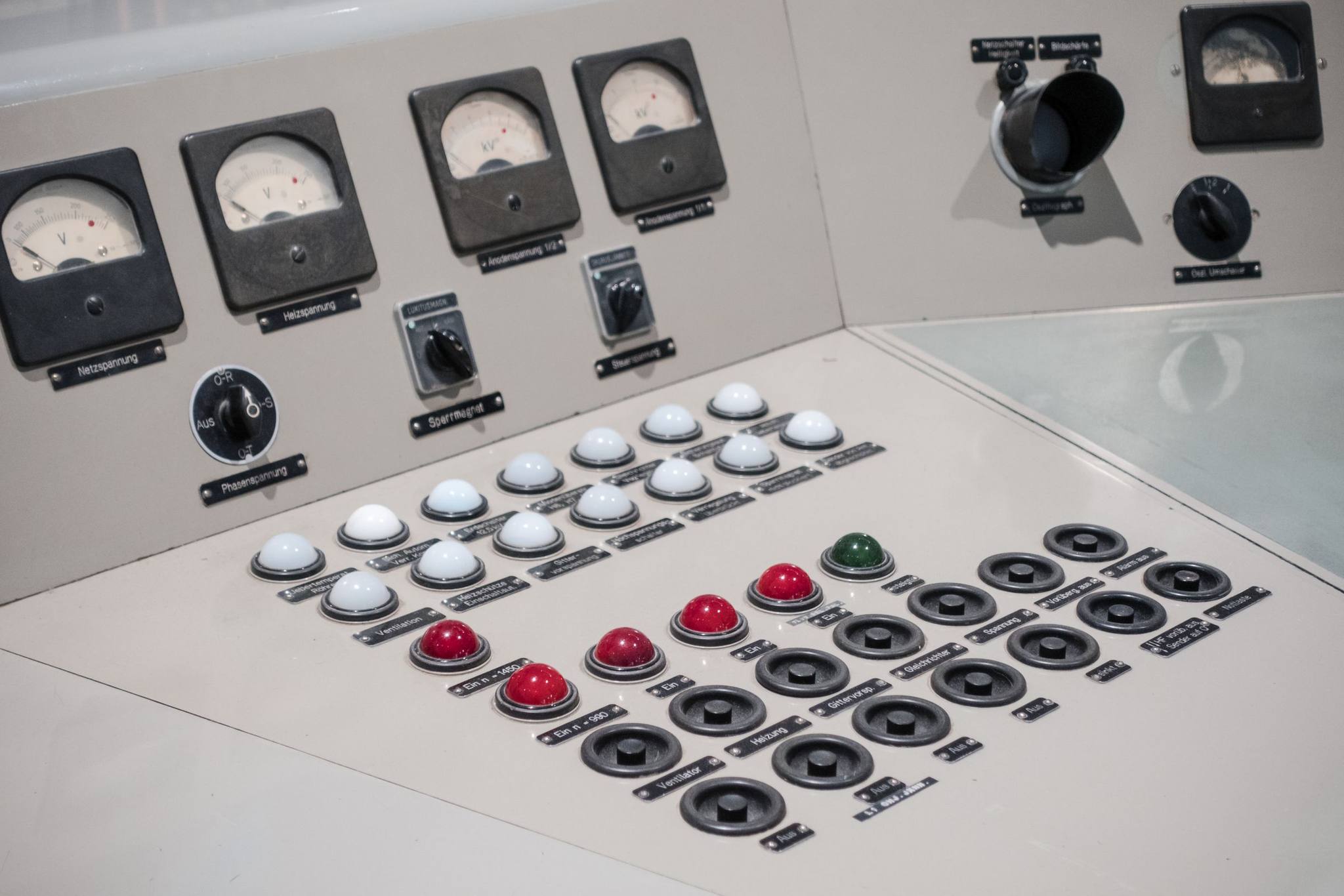 An old analogue control desk with dials, rotary switches and rows of push buttons